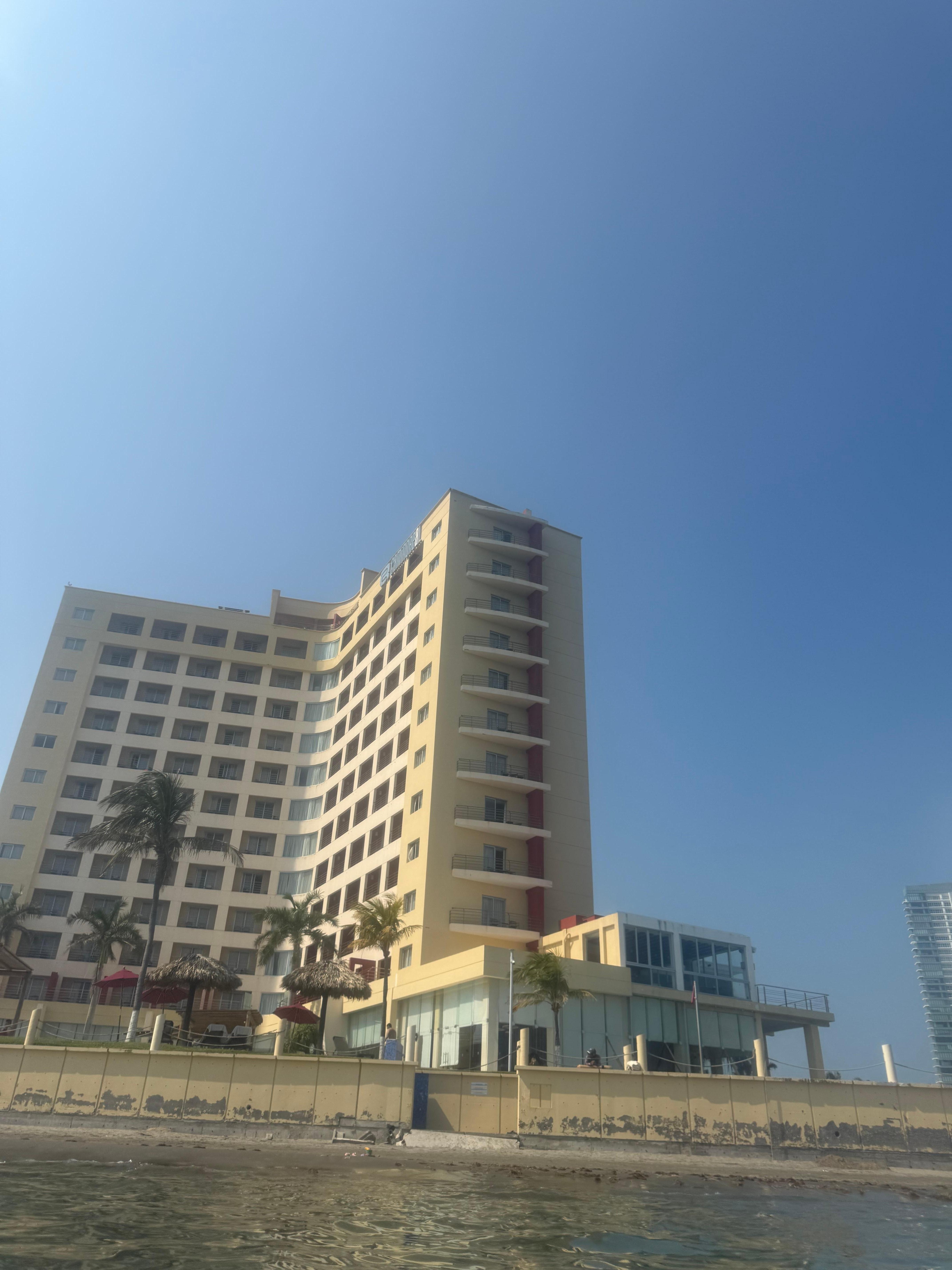 Vista desde el mar hacia el hotel, los ventanales grandes hasta enfrente, son las habitaciones juniors 