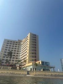 Vista desde el mar hacia el hotel, los ventanales grandes hasta enfrente, son las habitaciones juniors