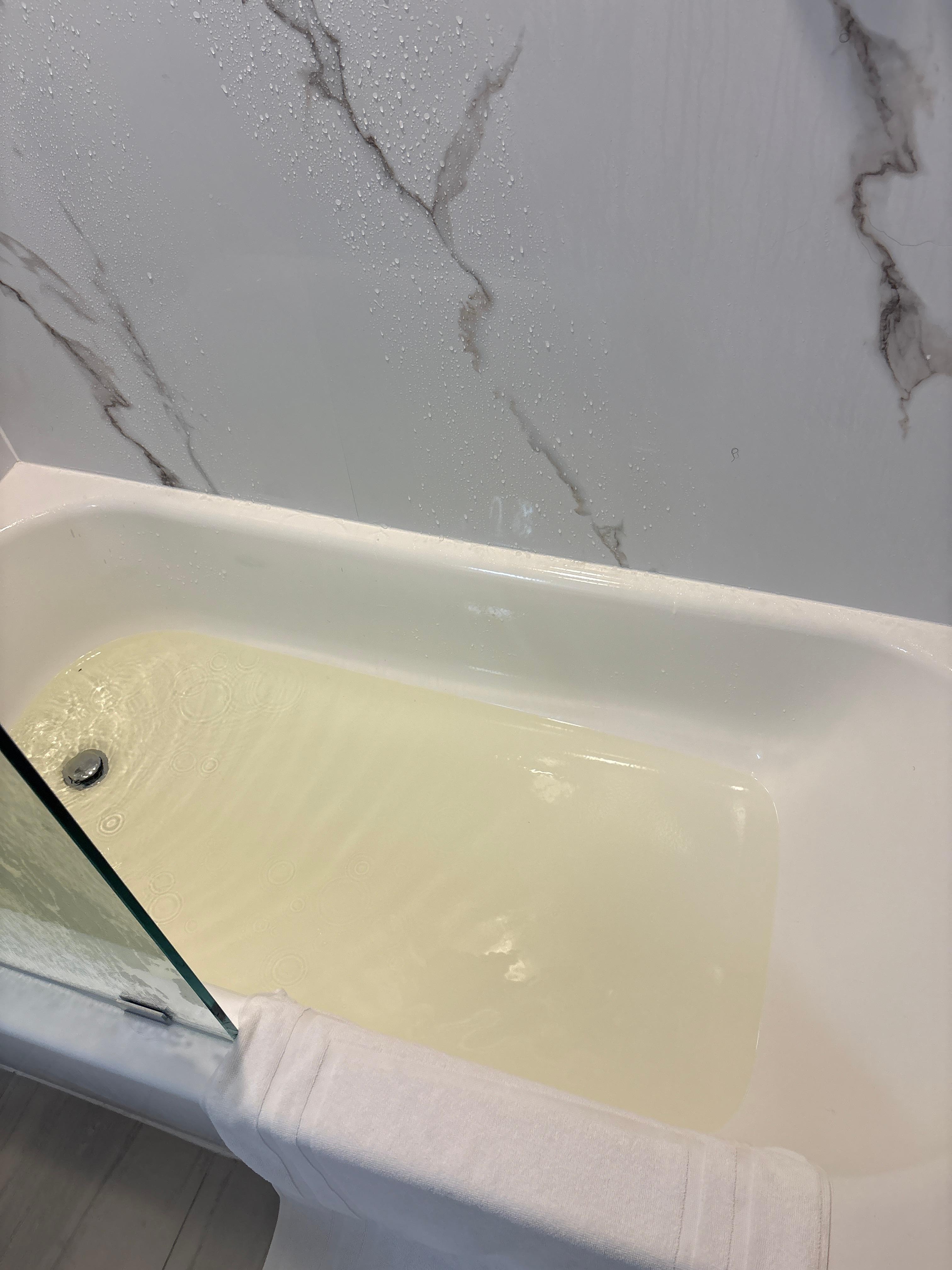 Yellow water in clogged bath.