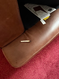 Half smoked spliff under armchair cushion