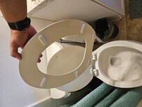 Broken toilet seat. This toilet was also loose from the foundation.