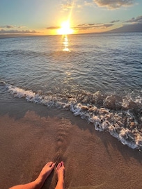 Feet in the sand at sunset