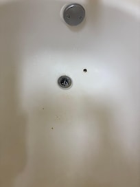 Bathtub with rusty holes and no stopper
