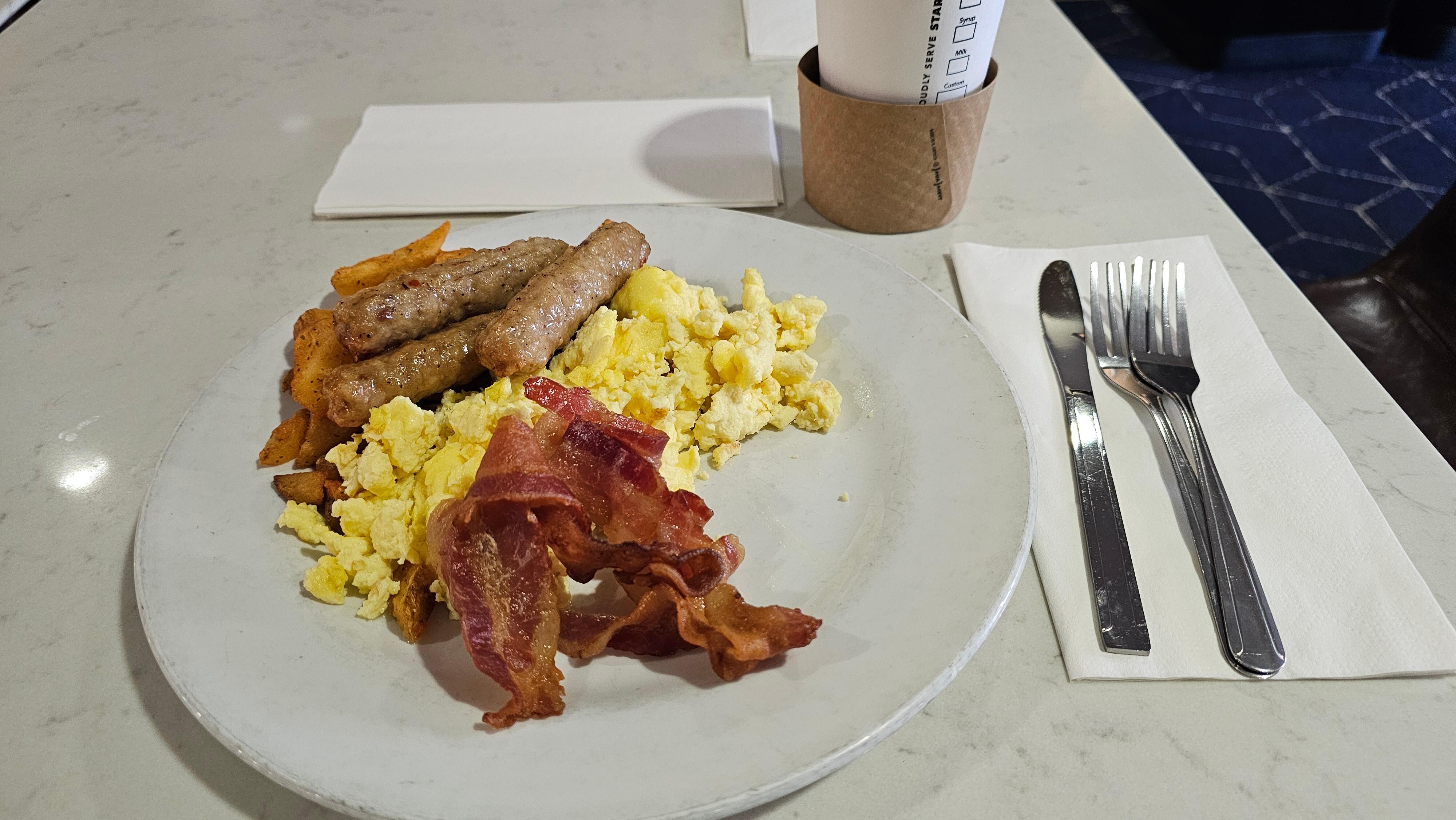 Food from the breakfast buffet includes, eggs bacon, potatoes, pancakes, toast, etc.