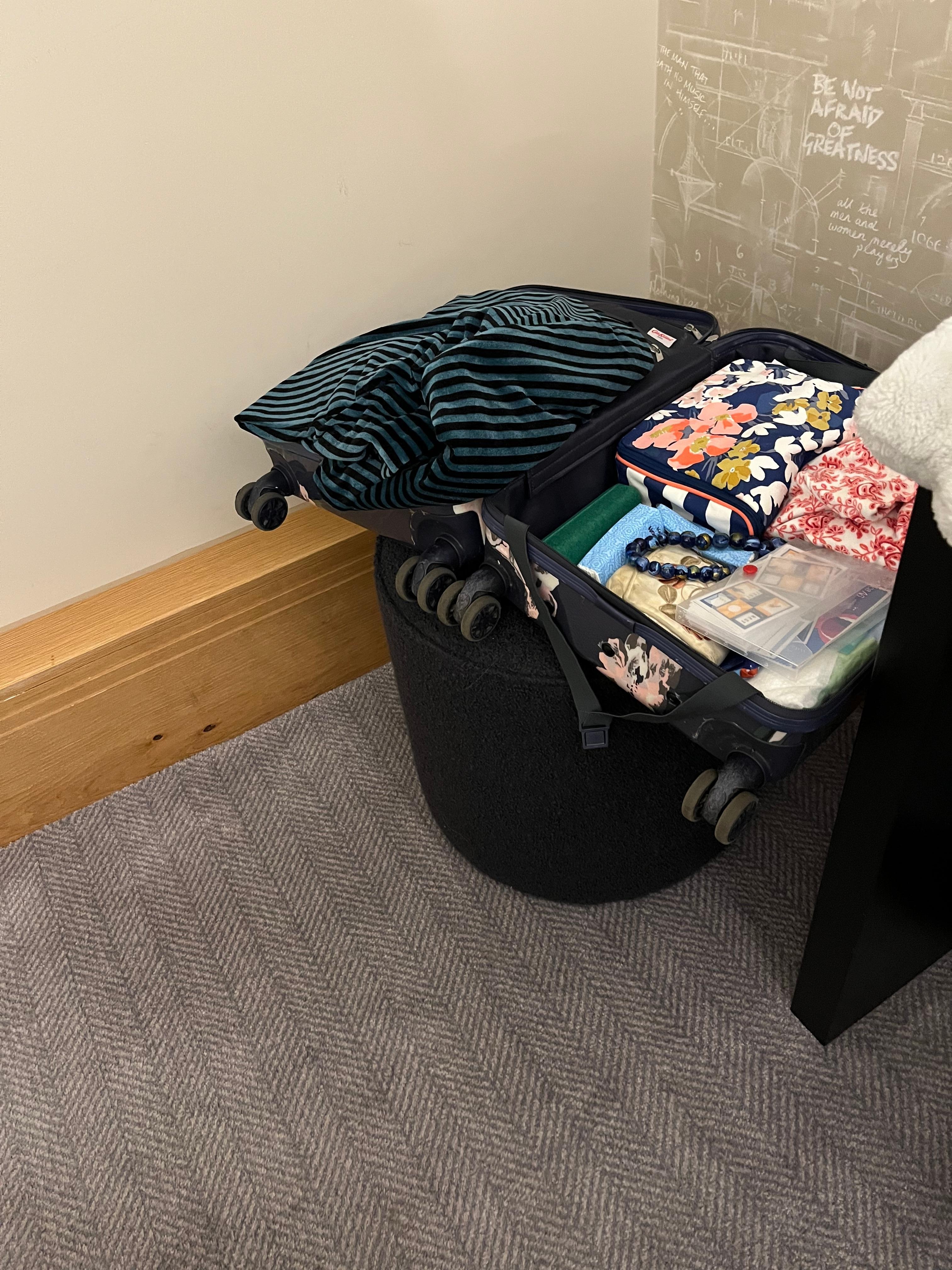 Unsteadily balancing my small suitcase on the pouffe that replaced the previously good office chair, as there was no suitcase stand or any other place to put my suitcase and no drawers to unpack into. 