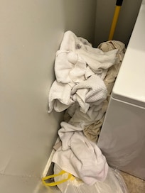 Put towels that were left in the dryer beside laundry unit. Smell terrible