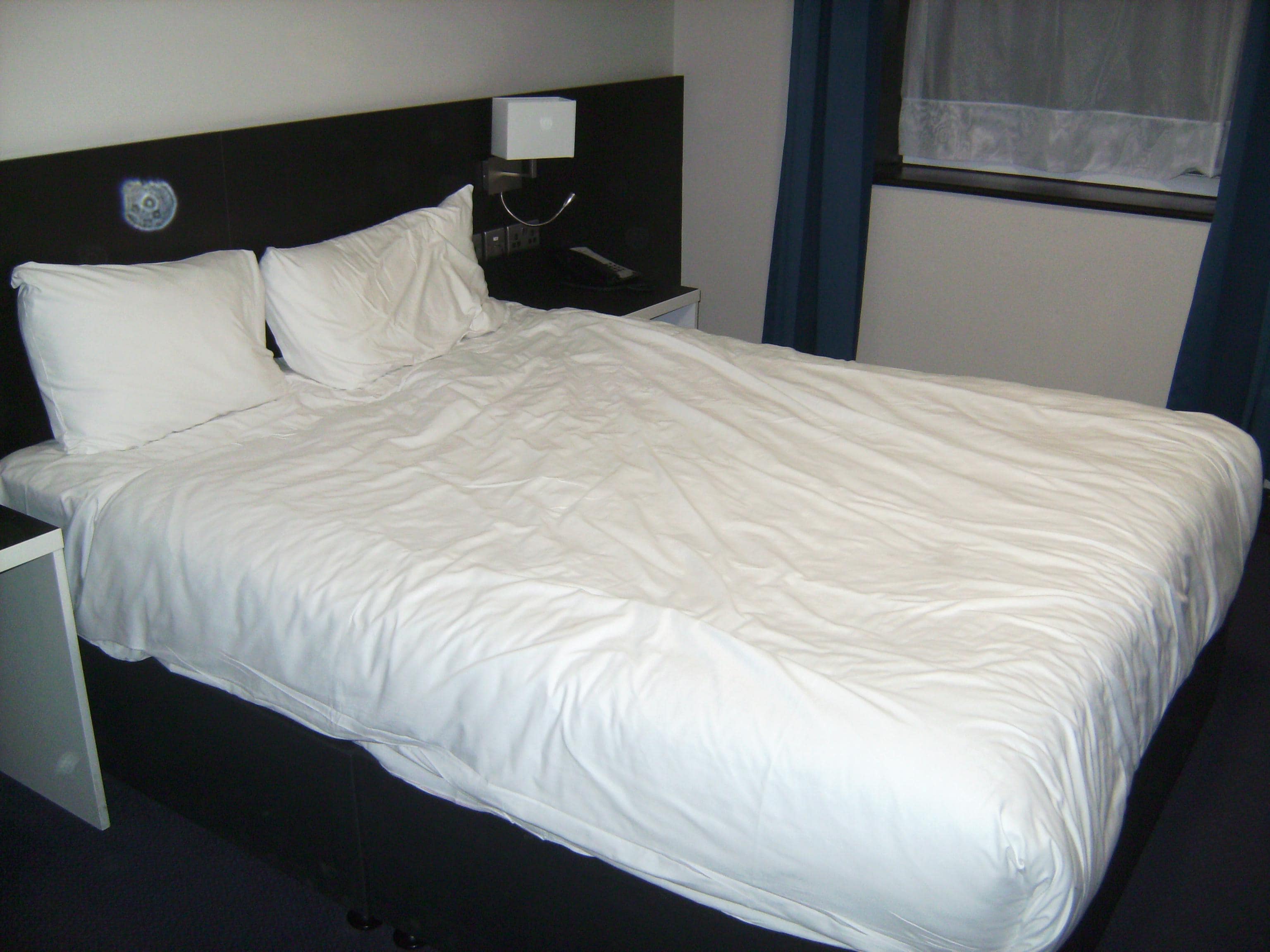 Comfy bed with bedside lights and plug sockets.