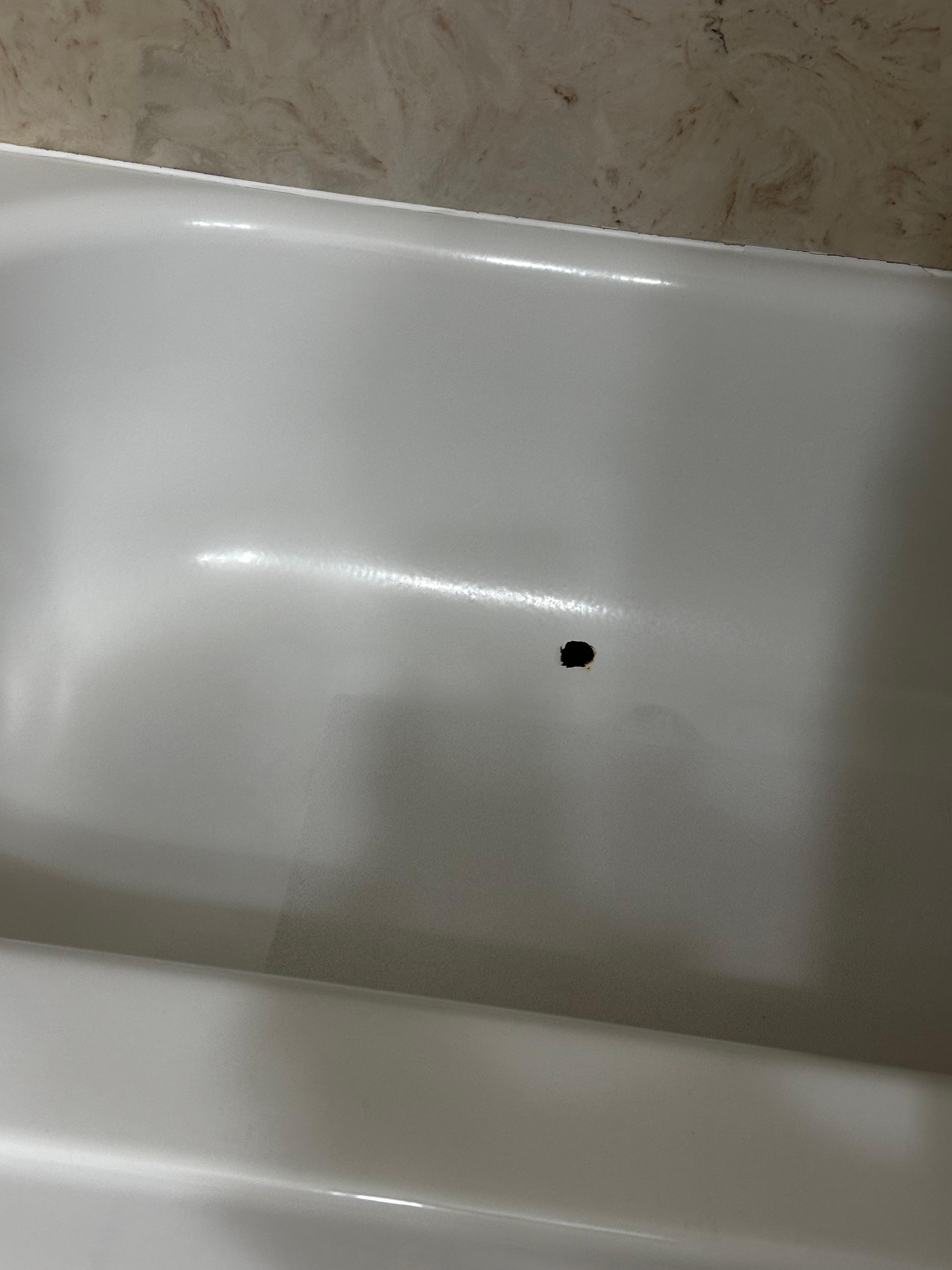 Exposed rusted spot in the tub