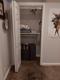 Closet in bedroom with cot and extra bedroom linens.