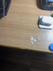 white sticker residue stuck to bedside table
