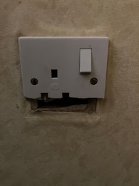 Unsafe plug socket - potential source of electrocution.