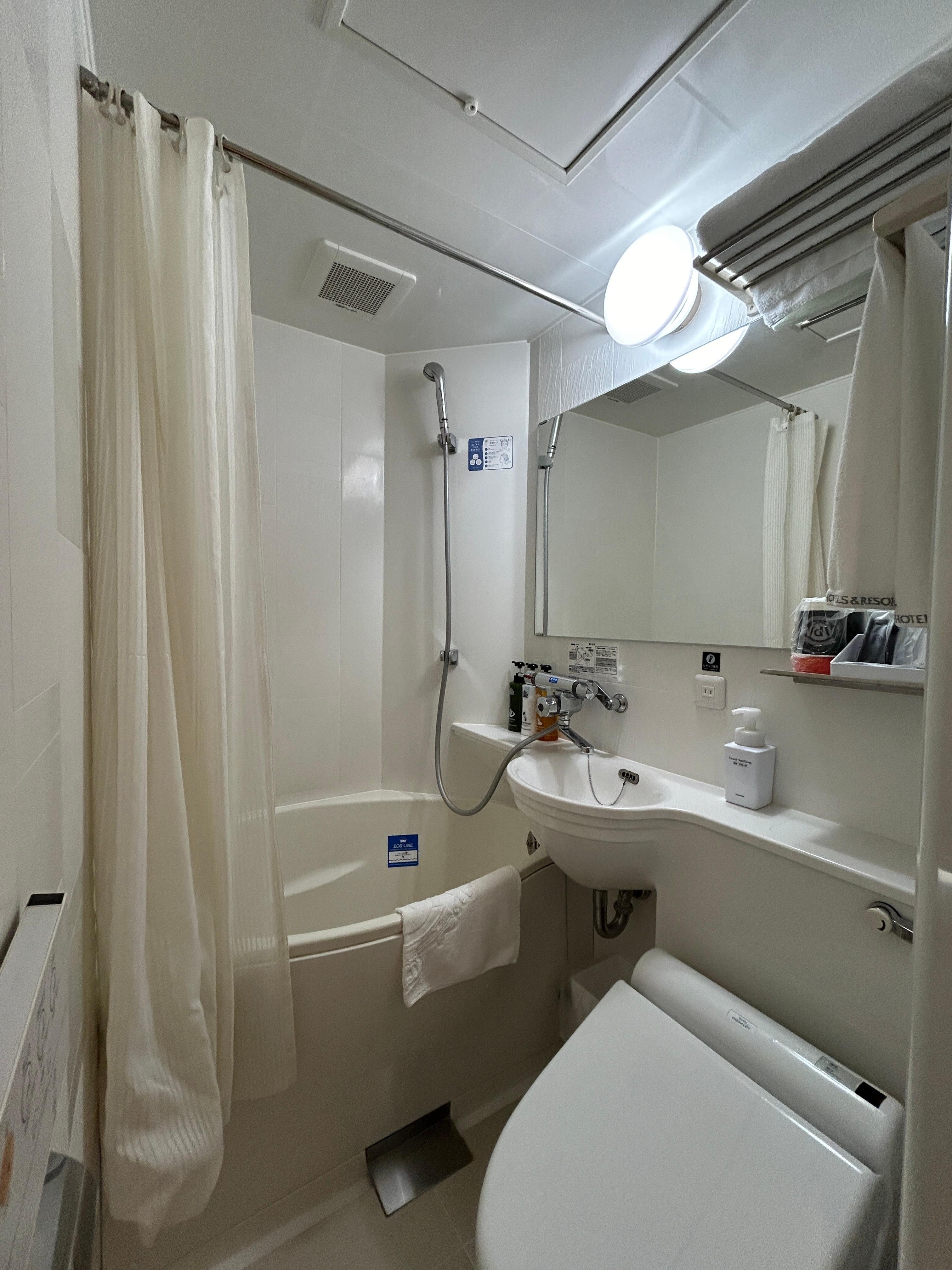 Small but fully functional bathroom with shower and bathtub. 