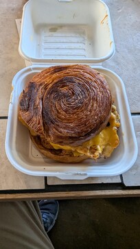 Grilled timber ring croissant, fried cage-free egg, local cheddar, chipotle honey mustard; choice of local sausage patty, grilled ham, avocado, or 2 pieces local bacon from local cafe Le Croissant in nearby Logan