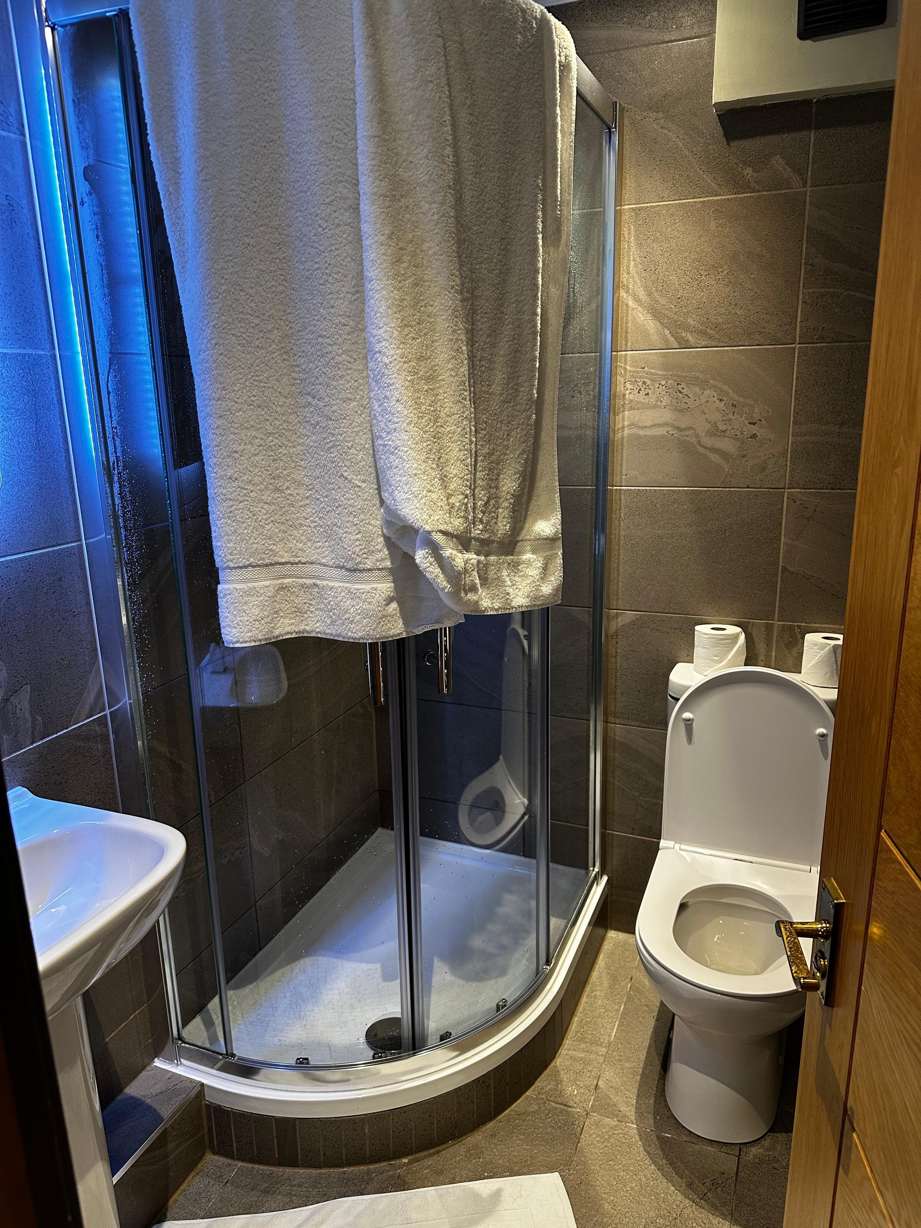 Tiny shower and no place for towels except the sink.