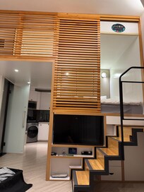 Vom Sofa aufgenommen in einem Einzelzimmer. Vorne die Tür zum Badezimmer, rechts zur Küche. Inkl. allem TV, Klimaanlage etc. Treppe rauf ist der Schlafbereich.