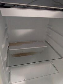 Broken and dirty mini fridge.