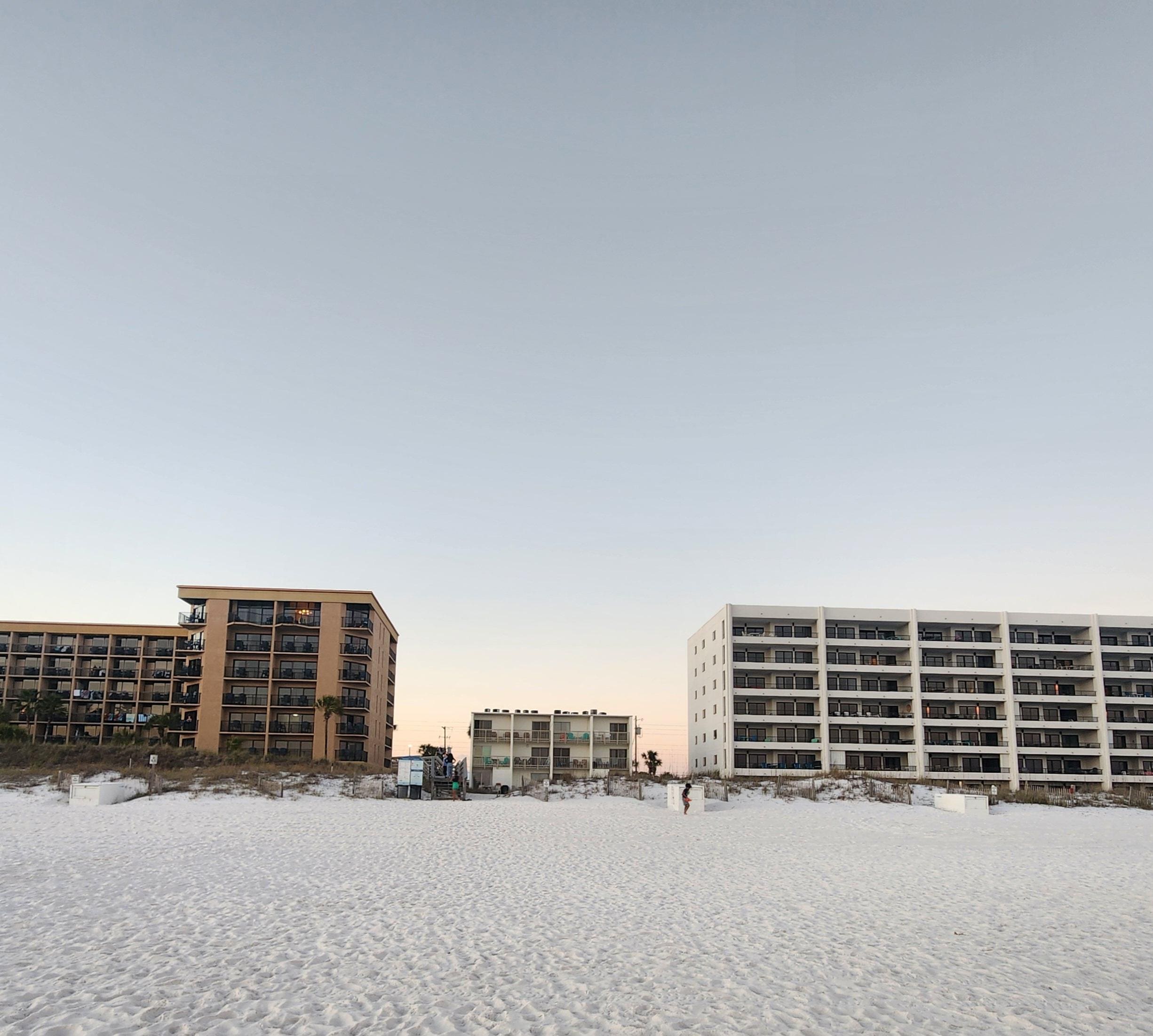 The complex is the smaller building between the newer, bigger buildings.