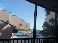 View of pool and ocean from screened-in porch