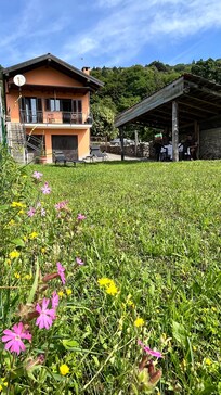 Garten Blick aufs Haus und Unterstand mit Tisch und StĂŒhlen