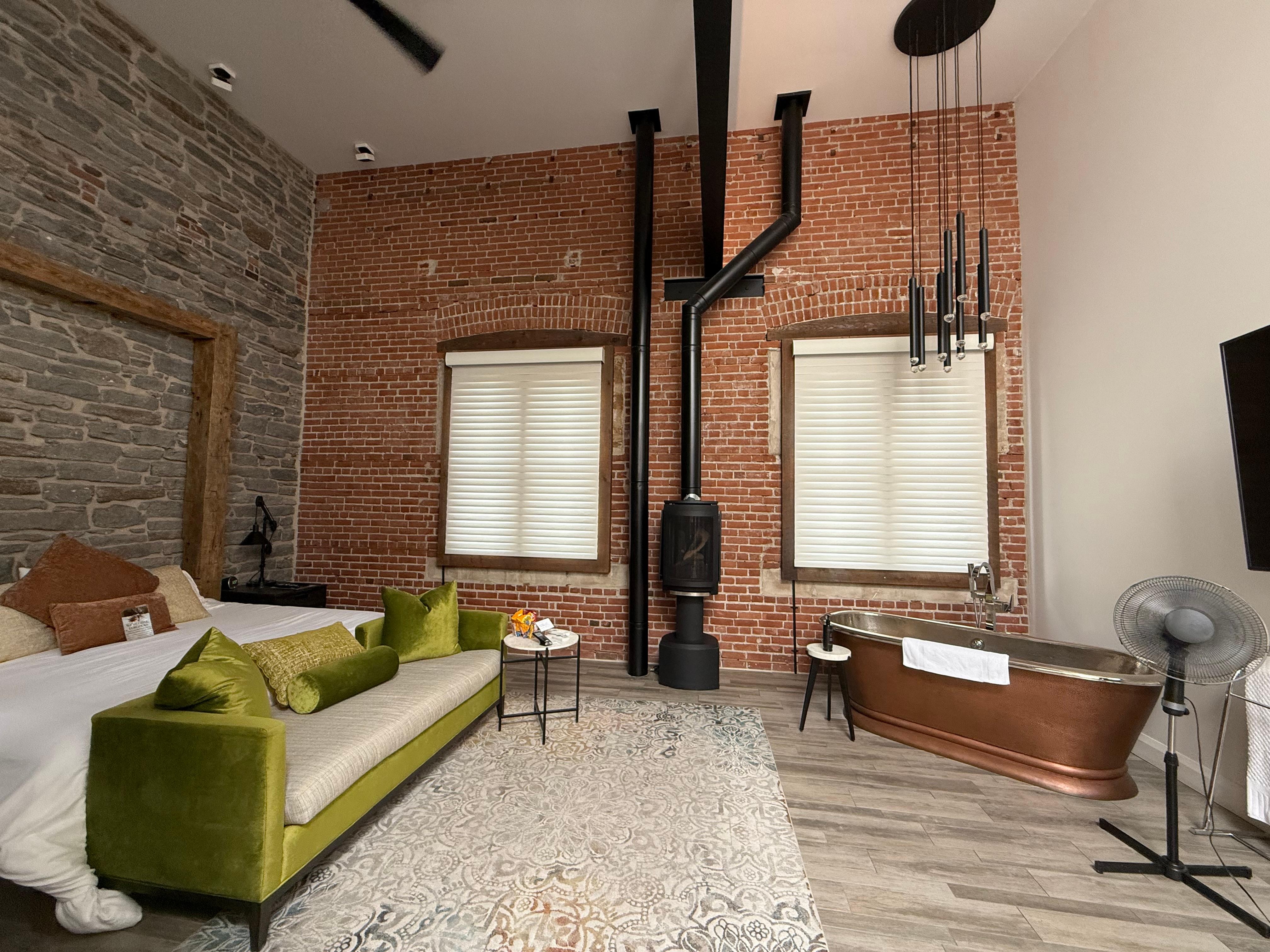 Main space with dealing fan and AC unit on wall above big screen tv.