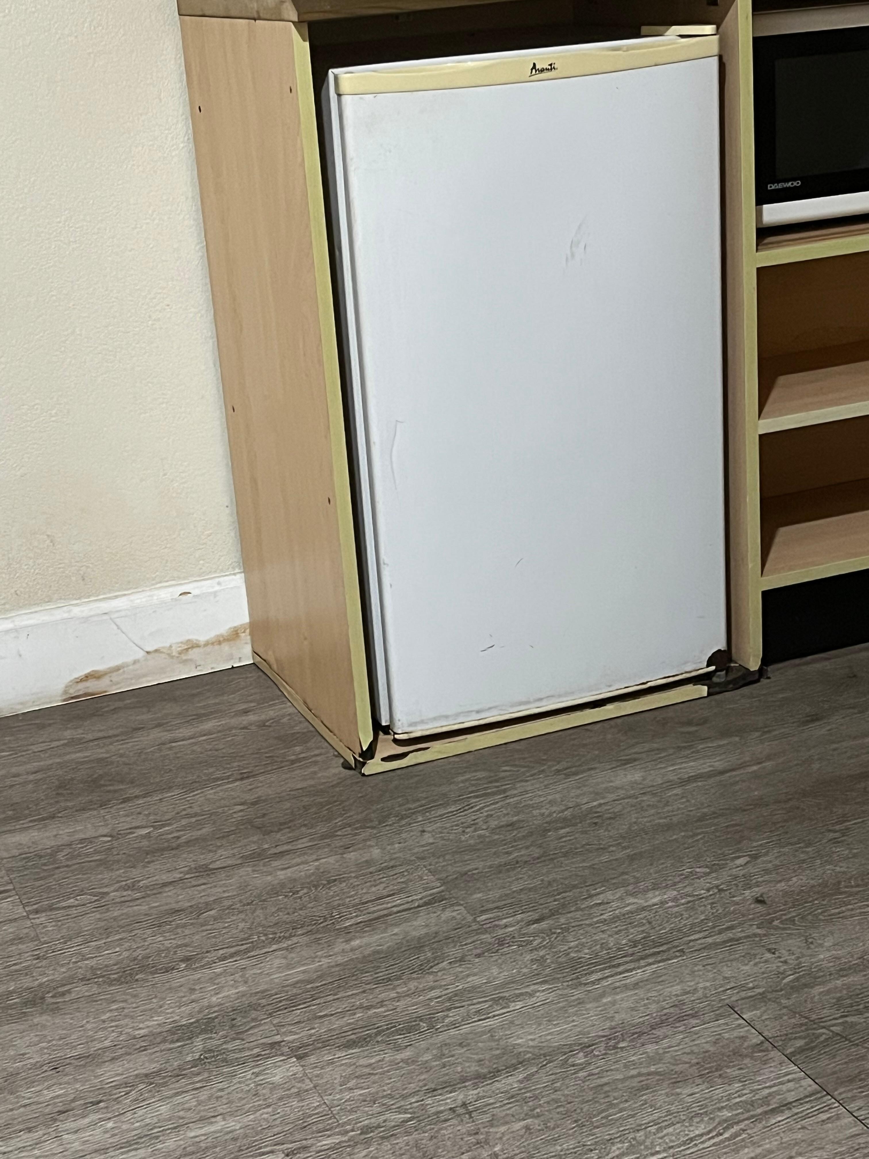 Water damage in the refrigerator cabinet and wall behind