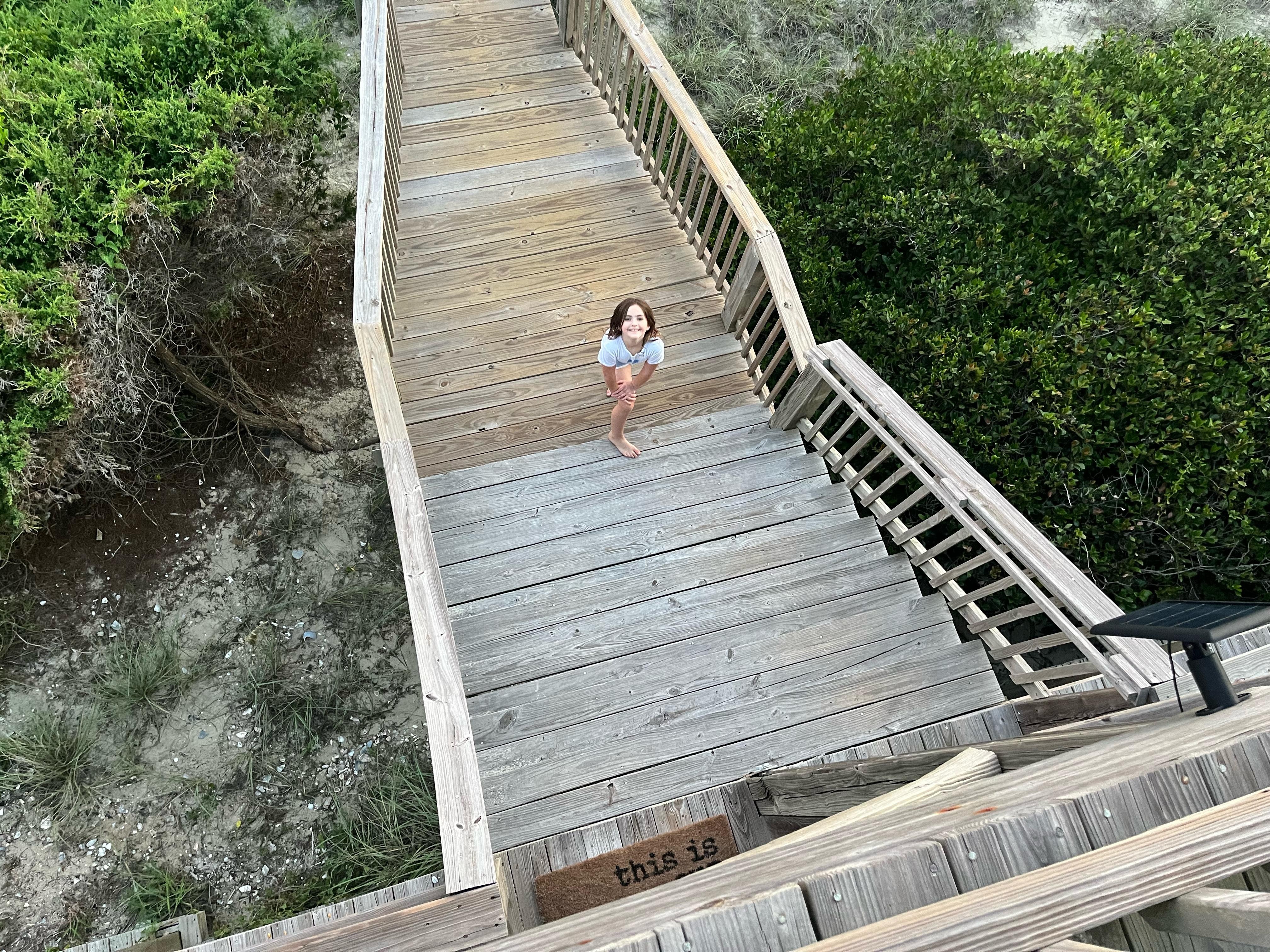 My granddaughter on the wooden walkway out to the beach. Loved having a place to rinse feet and bodies off, but there’s also an outside shower that was used, too!  