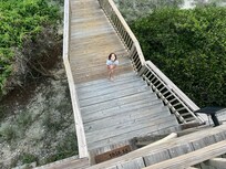 My granddaughter on the wooden walkway out to the beach. Loved having a place to rinse feet and bodies off, but thereâs also an outside shower that was used, too!