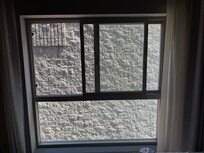 A gray wall view from the only window