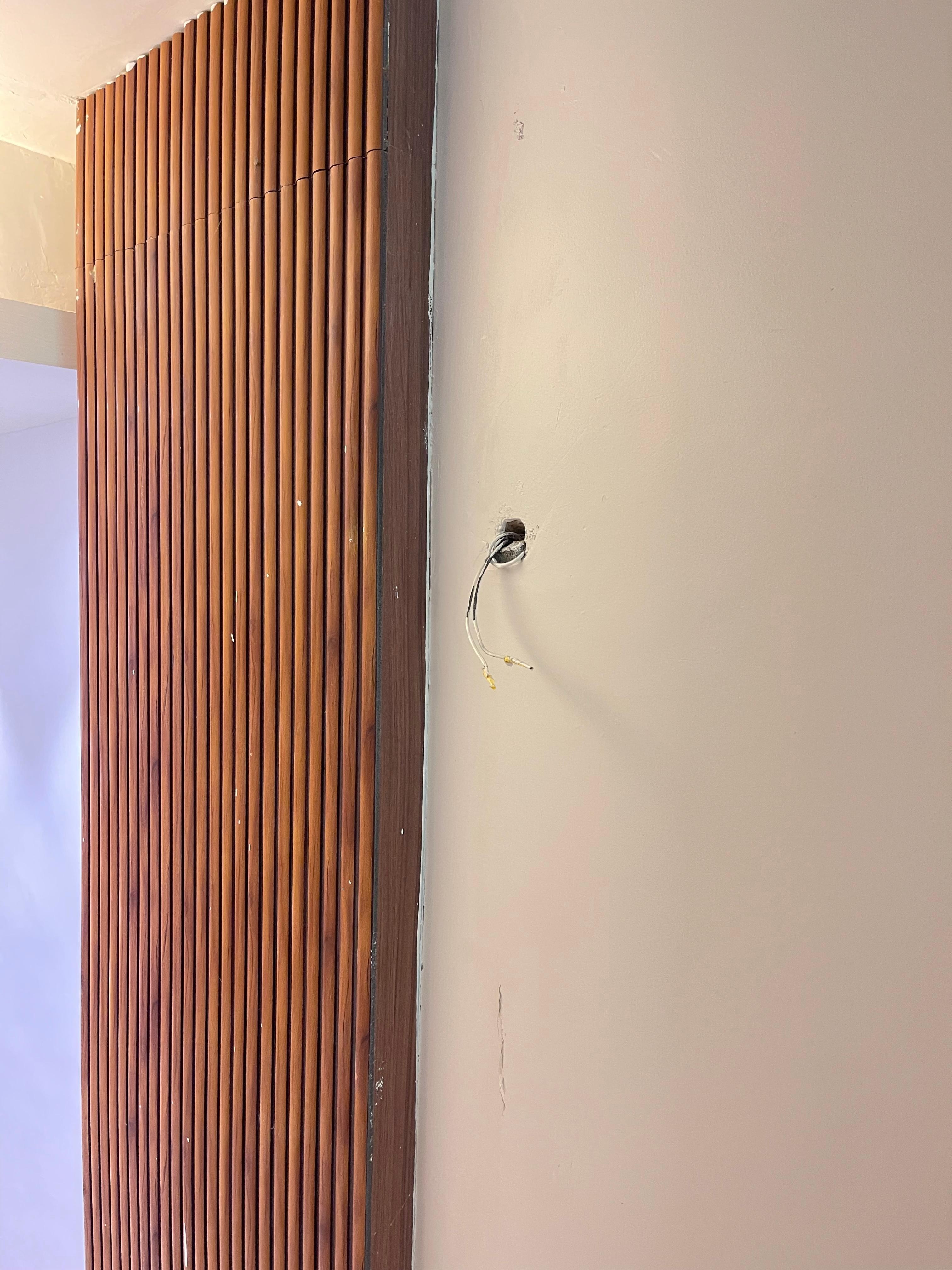 Exposed wires in the hallway posing electrocution risk
