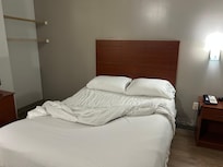 Room looking at the bed (we had already turned down the sheets to check for bedbugs)