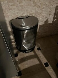 Trash can is greatly dented.