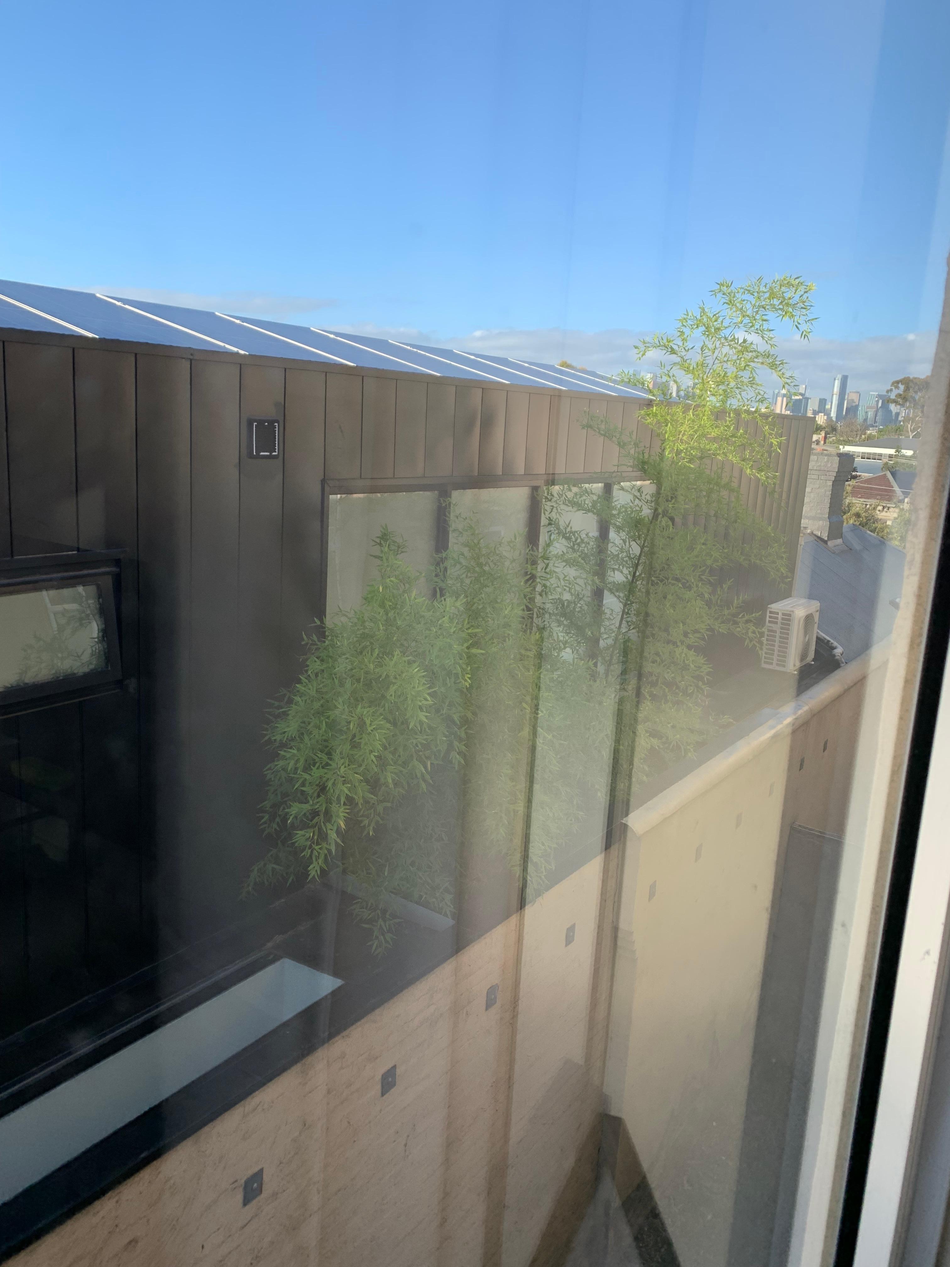 Just a glimpse of the city through a dirty window and flatscreen . 