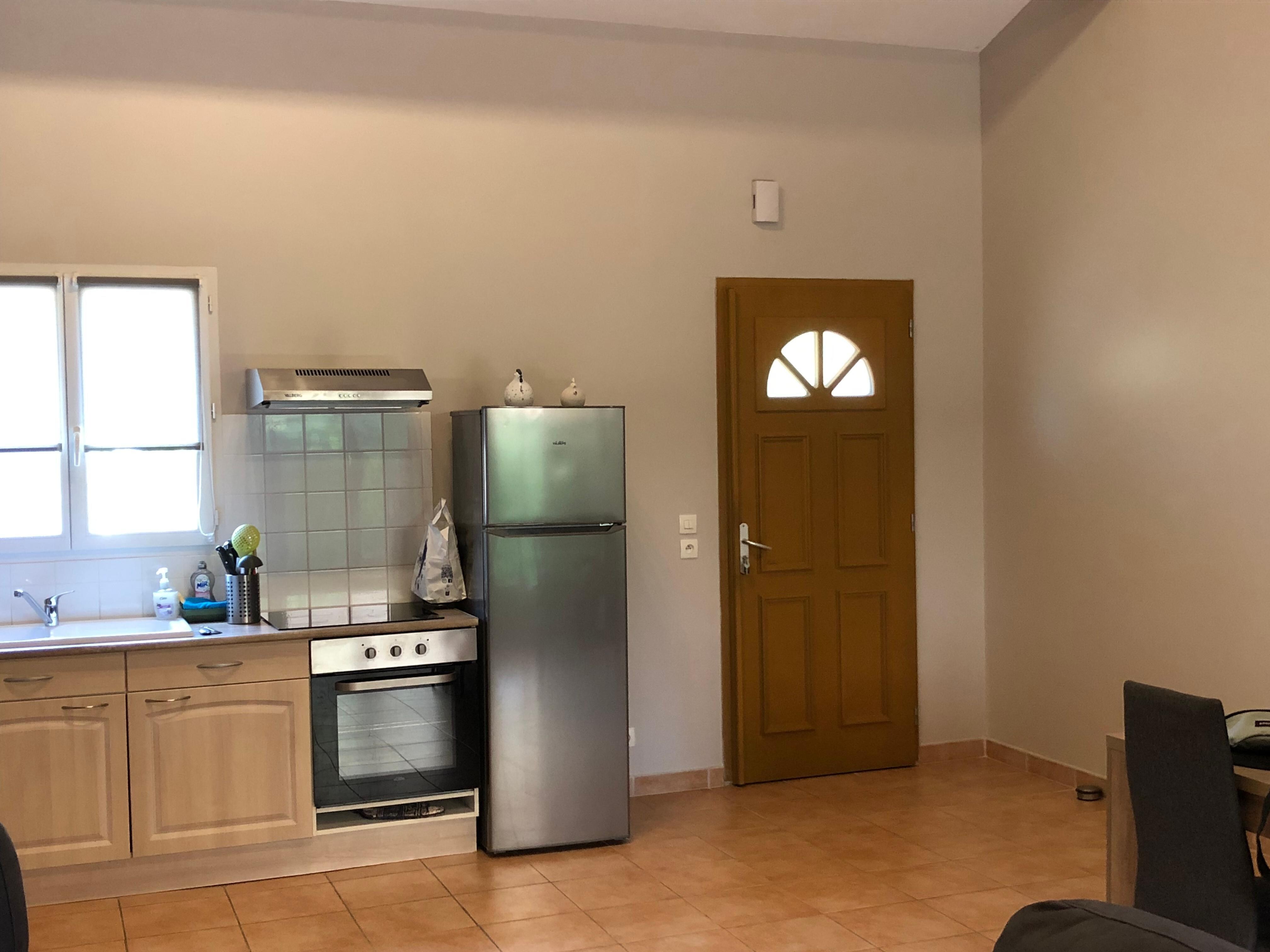 Porte d’entrée donnant sur la pièce de vie avec cuisine