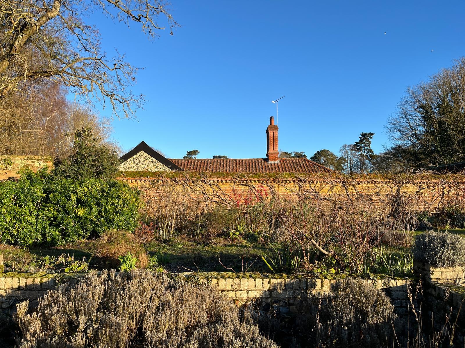 Gardeners Cottage peeking behind the walled garden.