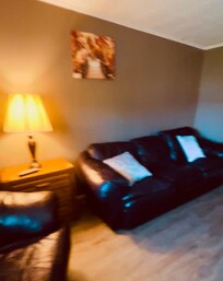 Deluxe room - Living Room (couch, chair, end table w/drawers, dining area w/2 chairs, storage chest w/linen, blanket, pillows)