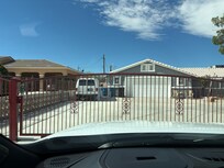 Note Van in driveway with covered wheels. Bars on windows.