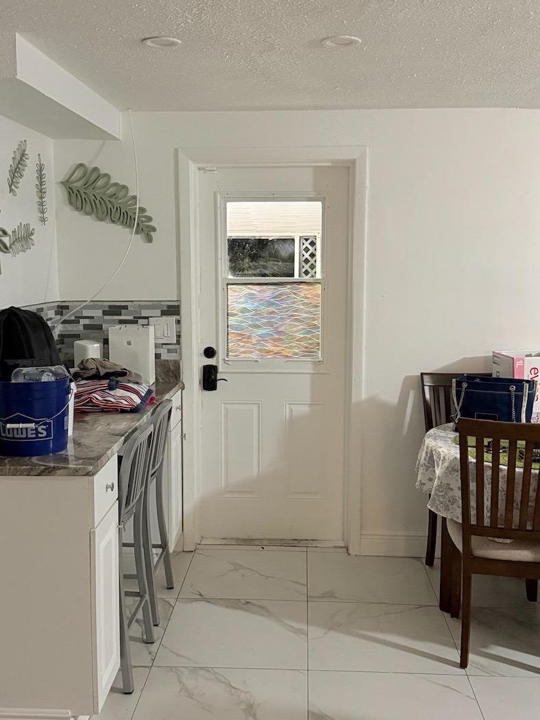 Entry door  into home where  anyone  outside   could look in and see living area and kitchen in full view.