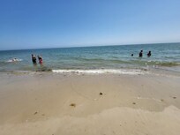 Calm, small waves, sand close to water