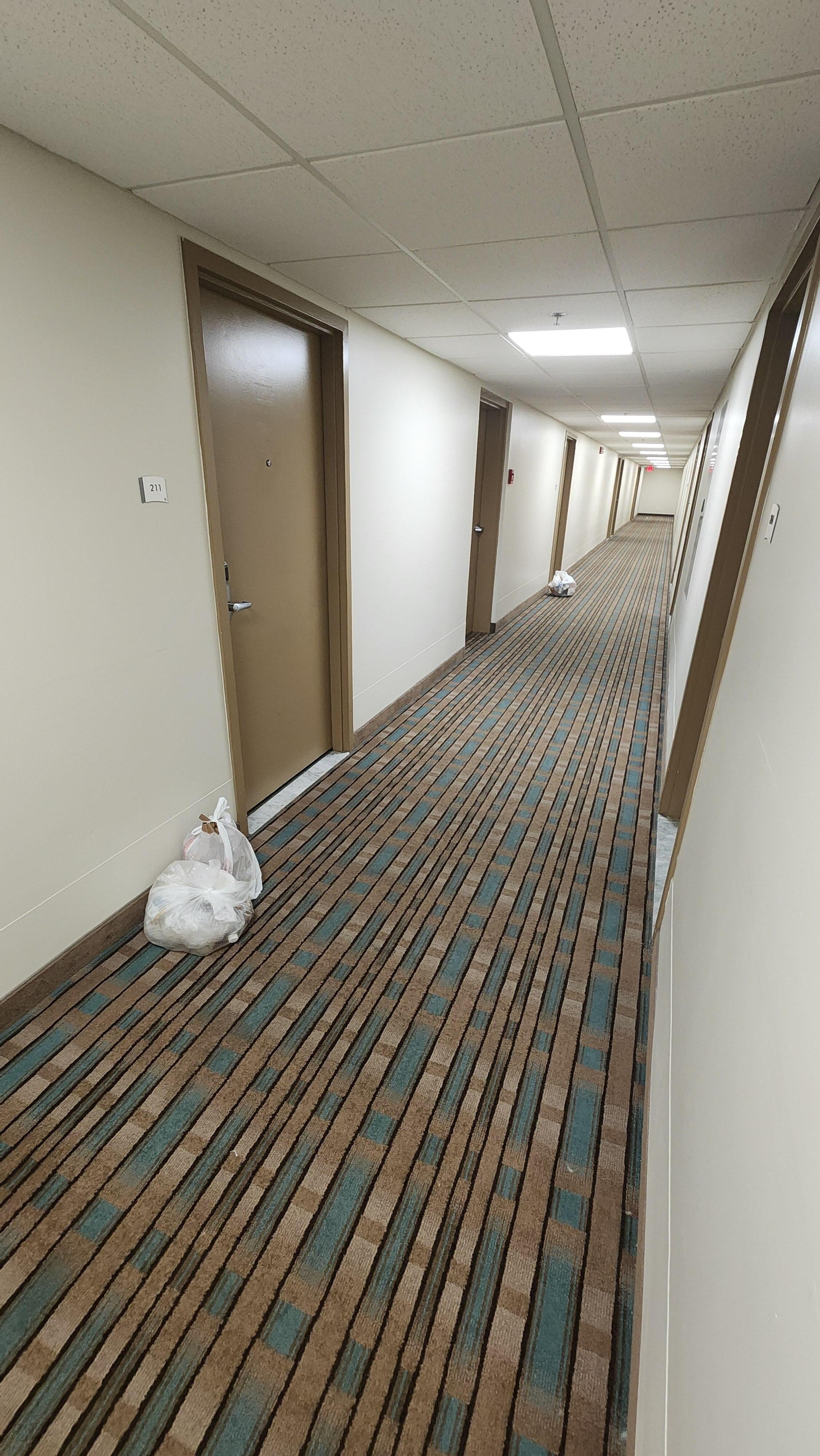 Trash bags down the hallway and debris in various place