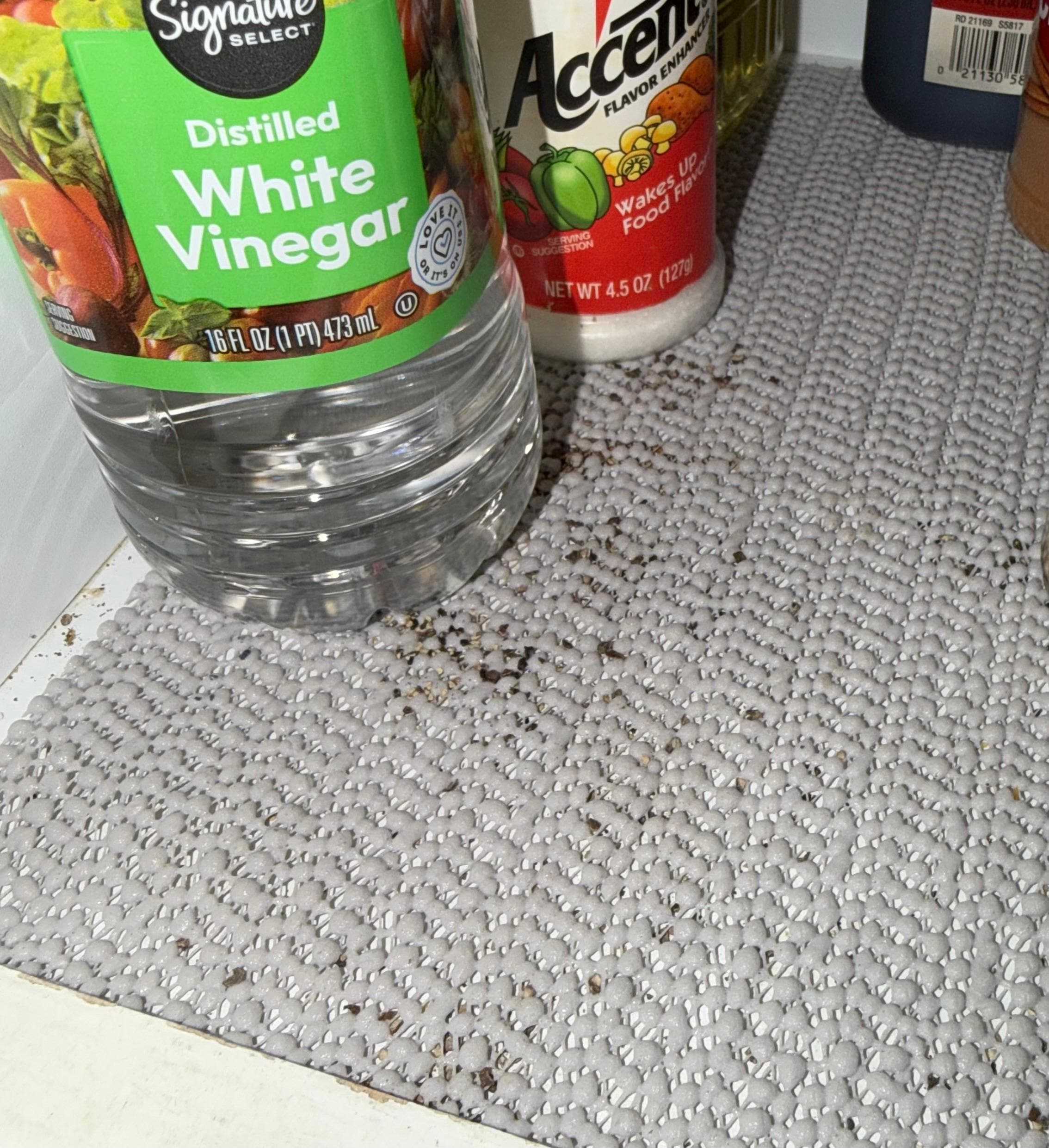 Mouse droppings in kitchen cabinet, next to food items.