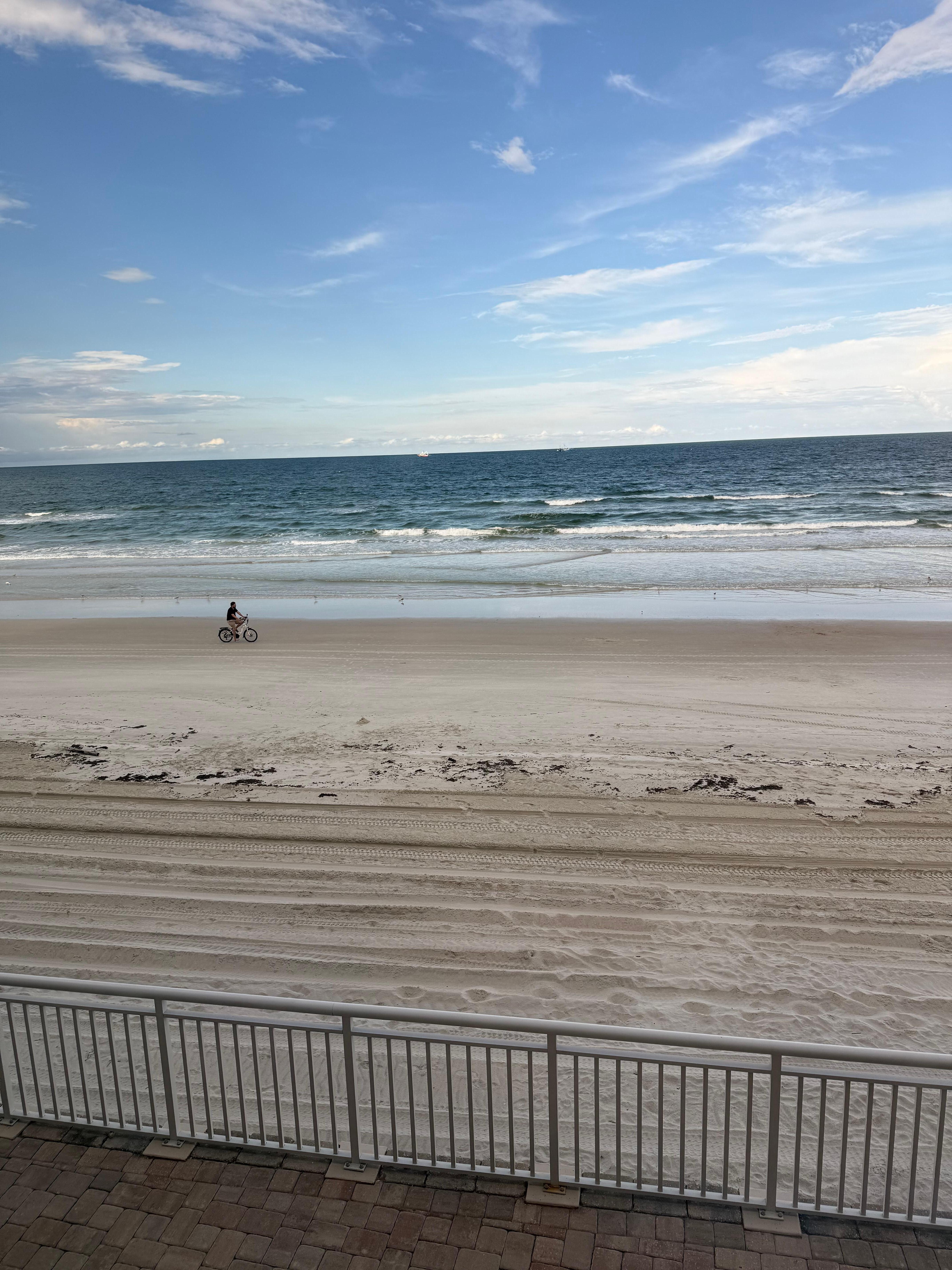 Bike rider on beach, view from balcony 