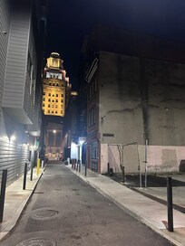 The rental is the building on right next to parking lot. It shares an alley with restaurants and a high end apartment building which uses the lot so unfortunately you can’t park there. But it was all well lit, clean and safe.