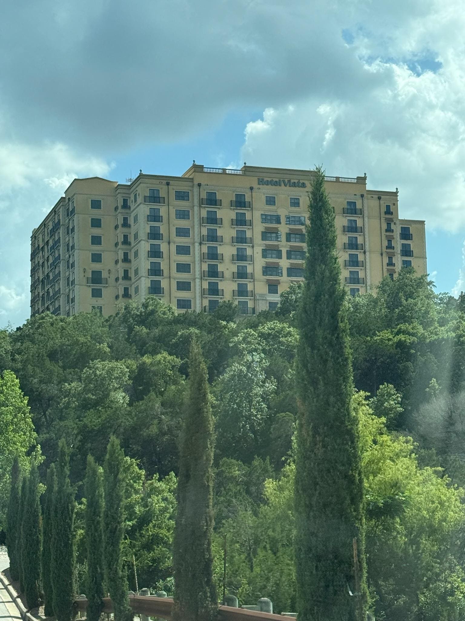 Hotel on a hill with a winding road to the top.