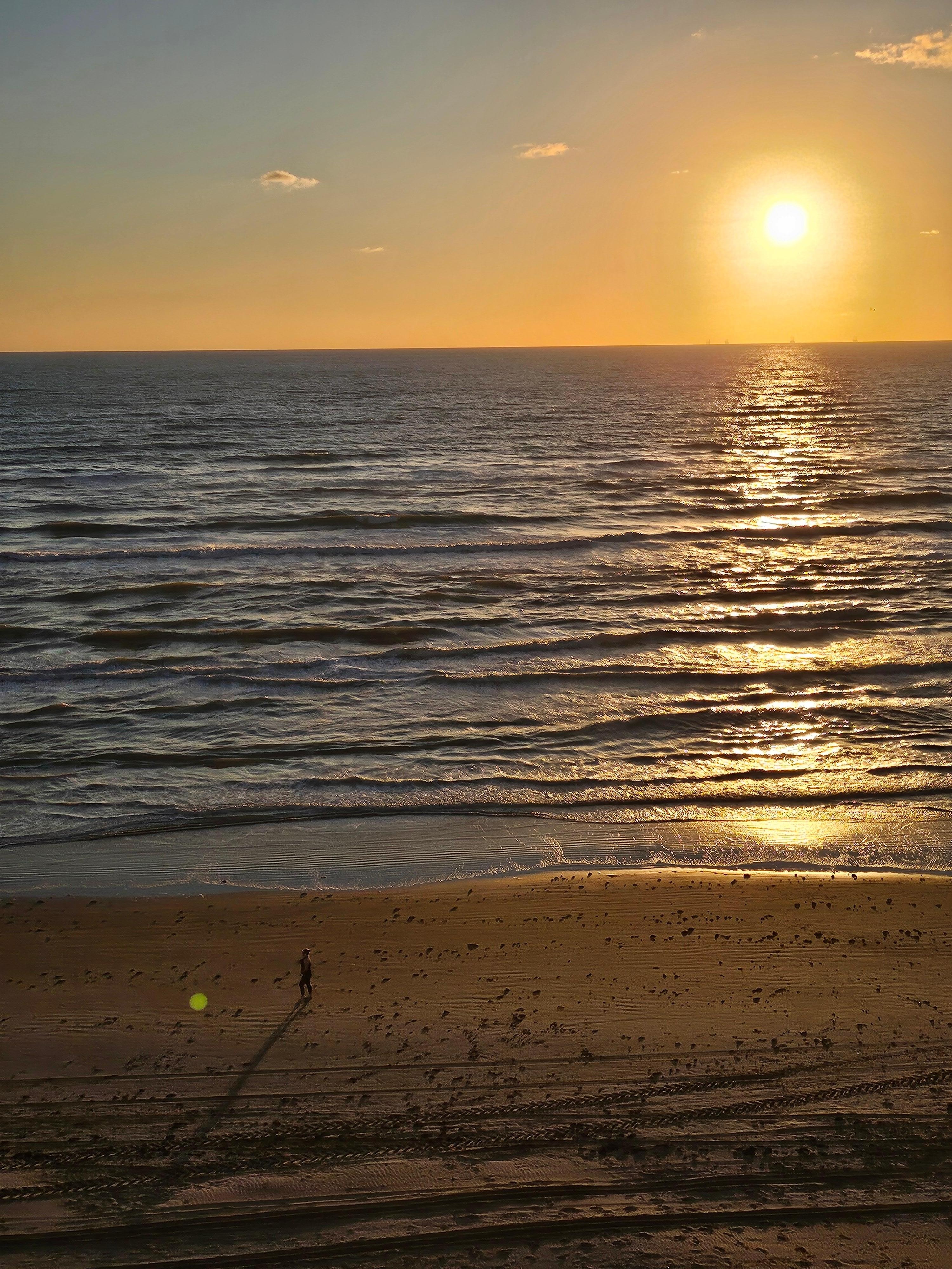 Sun rising from the ocean, reaching sky ward.