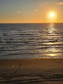 Sun rising from the ocean, reaching sky ward.