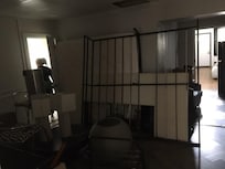 The living room, with all the furniture disassembled and stacked up, along with boxes of personal belongings.