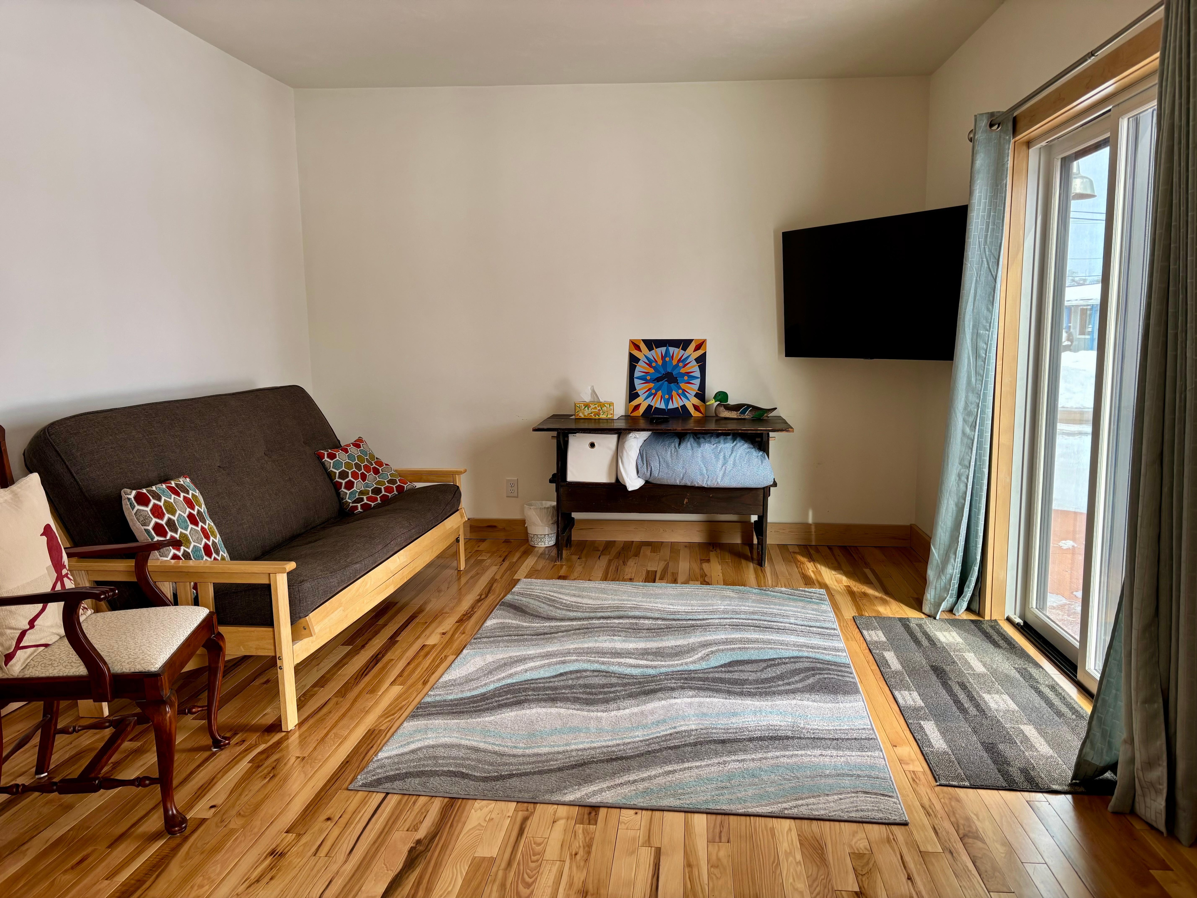 Additional living space with TV and comfortable futon. Sliding doors to patio. 