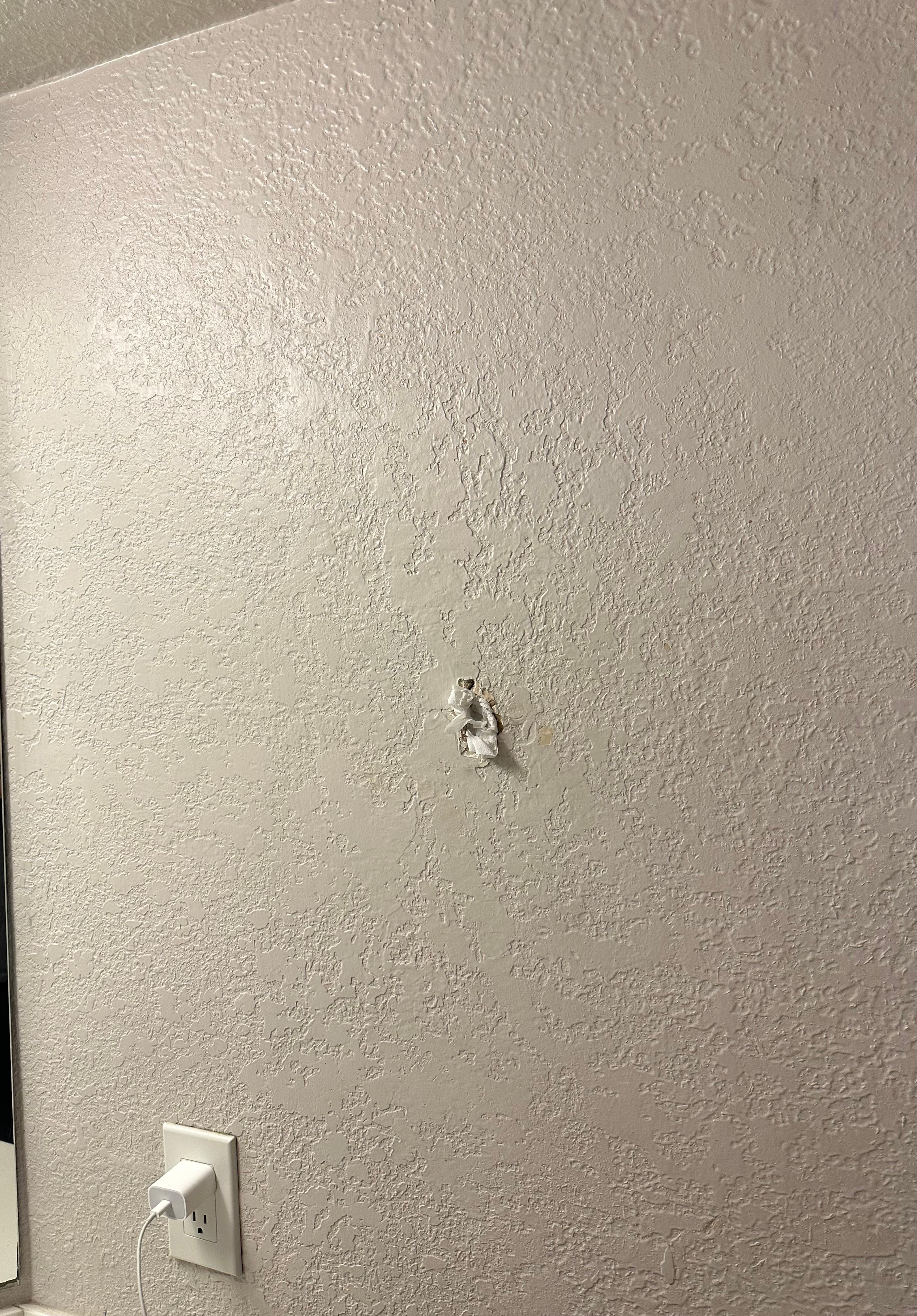 Holes on the wall covered with what seemed like toilet paper.