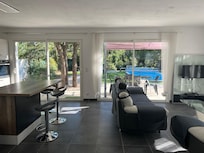 Séjour cuisine avec vue sur la terrasse et la piscine.