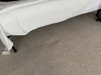 A hole in the floor beside an upstaris bed.